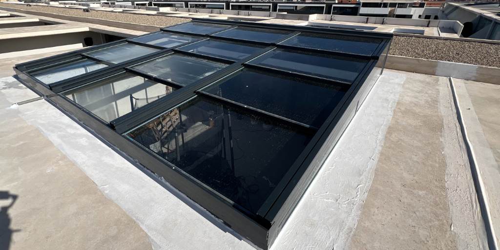 techo corredizo sobre hueco de terraza de hormigón, motorizado y con cristal