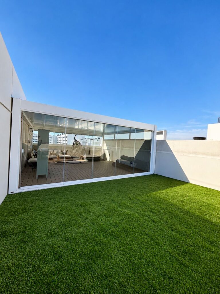 Cerramiento de ático con puertas correderas de cristal sin perfiles, instalado por Isoconfort en Zaragoza